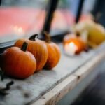 Close-up of pumpkins on a window sill during fall, creating a warm, seasonal atmosphere.