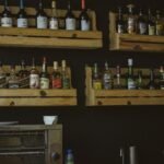 A rustic wooden shelf display of liquor bottles on a dark wall, perfect for a bar setting.